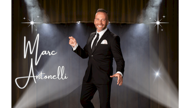 A man in a black suit poses on a stage with spotlights and stars, "Marc Antonelli" written in cursive on the left.