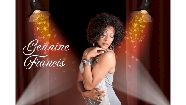 Gennine Francis posing gracefully on stage under spotlights, wearing a silver dress and shimmering bracelets.